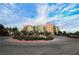 Beautiful exterior of the multi-story building surrounded by lush greenery and a circular driveway at 30 Strada Di Villaggio # 115, Henderson, NV 89011