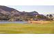 Picturesque view of the golf course and lake, set against a backdrop of mountains and luxury homes at 30 Strada Di Villaggio # 115, Henderson, NV 89011
