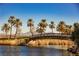 Picturesque landscape featuring a charming bridge over water, palm trees, and distant mountains under a clear sky at 30 Strada Di Villaggio # 115, Henderson, NV 89011