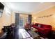 Bright living room with a red couch and dining table at 30 Strada Di Villaggio # 115, Henderson, NV 89011