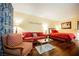 Living room with red couch, armchair, and coffee table at 30 Strada Di Villaggio # 115, Henderson, NV 89011