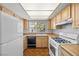 Galley kitchen with wood cabinets and white appliances at 4338 Caliente St # 14, Las Vegas, NV 89119