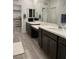 Bright bathroom boasts dual sink vanity, framed mirrors, and gray wood-look floors at 4372 Panoramic View Ave, North Las Vegas, NV 89084