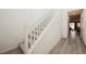 Carpeted staircase with white railings leading to the upper level with an open hallway at 4372 Panoramic View Ave, North Las Vegas, NV 89084