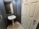 Small bathroom with pedestal sink and gray walls at 6524 Heavenly Moon St, North Las Vegas, NV 89084