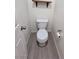 Clean bathroom with toilet, floating shelf, and gray floor tiles at 6524 Heavenly Moon St, North Las Vegas, NV 89084