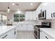 Modern white kitchen with stainless steel appliances and quartz countertops at 9085 Bridal Creek Ave, Las Vegas, NV 89178