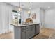 Modern kitchen with gray cabinets, granite island, and stainless steel appliances at 92 Kimberlite Dr, Henderson, NV 89011