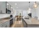 Open concept kitchen with gray cabinets, granite countertops, and stainless steel appliances at 92 Kimberlite Dr, Henderson, NV 89011