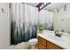 Bathroom with forest shower curtain and wood vanity at 11015 Dornoch Castle St, Las Vegas, NV 89141