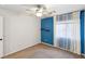 Bright bedroom with blue accent wall, ceiling fan, and neutral carpeting at 11015 Dornoch Castle St, Las Vegas, NV 89141