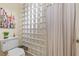 Small bathroom with toilet, glass block shower, and updated vanity at 1319 Red Baron Ln, Boulder City, NV 89005