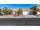 Front view of a single-story house with palm trees and a garage at 1384 Glassy Pond Ave, Las Vegas, NV 89183