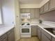 White stove and microwave in this kitchen with taupe cabinets at 2036 Mesquite Ln # 303, Laughlin, NV 89029