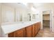 Double vanity bathroom with wood cabinets and large mirror at 2149 Cedar River Ct, Henderson, NV 89044