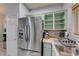 Kitchen corner with stainless steel refrigerator and light green cabinets at 3262 Mystic Ridge Ct, Las Vegas, NV 89129