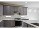 Modern kitchen features gray cabinets, stainless steel appliances and quartz countertops at 4119 Amberdale Ave, North Las Vegas, NV 89031