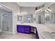 Bright ensuite bathroom features double sinks, decorative mirrors, and glass door shower at 4123 Redfield Ave, North Las Vegas, NV 89032