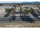 Wide shot of a desert property with a cozy home, mature trees, ample parking, and a scenic mountain view at 561 Jarvis Rd, Pahrump, NV 89060