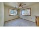 Bonus room featuring two large windows, neutral paint and flooring, and a ceiling fan at 561 Jarvis Rd, Pahrump, NV 89060