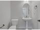 Modern powder room with pedestal sink, toilet, and neutral color palette at 5625 Galivan Vista St, North Las Vegas, NV 89081