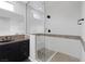 Bright bathroom with double sinks and seamless glass shower enclosure with tiled walls at 5625 Galivan Vista St, North Las Vegas, NV 89081