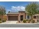 Single-story home with a tile roof, brown stucco, desert landscaping, and a two-car garage at 5625 Galivan Vista St, North Las Vegas, NV 89081