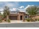 Single-story home with a tile roof, brown stucco, desert landscaping, and a two-car garage at 5625 Galivan Vista St, North Las Vegas, NV 89081