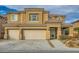 Two-story house with tan exterior, three-car garage, and landscaped yard at 6917 Snow Finch St, North Las Vegas, NV 89084