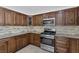 Modern kitchen features stainless steel appliances, granite countertops, tile backsplash, and custom cabinets at 7220 Stormson Dr, Las Vegas, NV 89145