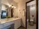 Bathroom vanity with a decorative mirror and open doorway to a bathtub and toilet at 725 N Royal Crest Cir # 215, Las Vegas, NV 89169