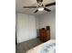 Bedroom with a ceiling fan, wood-look floors, dresser, and a sliding door closet at 725 N Royal Crest Cir # 215, Las Vegas, NV 89169