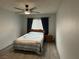 Bedroom with a simple bed, wooden nightstand, and a ceiling fan with dark curtains at 725 N Royal Crest Cir # 215, Las Vegas, NV 89169
