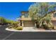Tan two-story home with attached garage and landscaped yard at 7611 Phoenix Peak St, Las Vegas, NV 89166