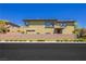 Tan two-story home with a large backyard and wall at 7611 Phoenix Peak St, Las Vegas, NV 89166