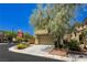 Tan two-story home with attached garage and mature trees at 7611 Phoenix Peak St, Las Vegas, NV 89166