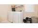 Bright laundry room with washer, dryer, and shelving at 7611 Phoenix Peak St, Las Vegas, NV 89166