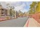 Gated community entrance with lush green trees and red brick accents at 7950 W Flamingo Rd # 2056, Las Vegas, NV 89147
