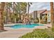 Community pool with palm trees, a water feature, and green landscaping at 7950 W Flamingo Rd # 2056, Las Vegas, NV 89147