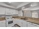 Eat in kitchen features stone countertops, all white appliances, and breakfast bar with view to dining room at 7950 W Flamingo Rd # 2056, Las Vegas, NV 89147