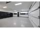 Organized garage with epoxy floors, storage cabinets, and space for multiple vehicles with overhead lighting at 1 Boulderback Dr, Henderson, NV 89012