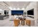 Open-concept living space featuring a modern kitchen, a fireplace, and city views at night at 1 Boulderback Dr, Henderson, NV 89012