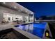 Modern backyard with a sparkling pool, sleek patio, and an outdoor dining area at 1 Boulderback Dr, Henderson, NV 89012