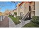 Exterior view of a light beige condo building with stairs, landscaping, and walkway at 1701 E Katie Ave # 10, Las Vegas, NV 89119
