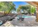Charming backyard featuring a pool, spa, covered patio, and mature trees at 29 Desert Highlands Dr, Henderson, NV 89052