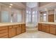 Spacious bathroom with double sinks, a tub, and travertine tile at 29 Desert Highlands Dr, Henderson, NV 89052