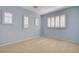 Bright bedroom with three windows dressed with plantation shutters, light blue walls and neutral carpet at 29 Desert Highlands Dr, Henderson, NV 89052