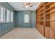 Bedroom with built-in bookshelves, ceiling fan, plantation shutters, and carpet at 29 Desert Highlands Dr, Henderson, NV 89052