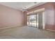 A primary bedroom features carpeted floors, ceiling fan, and sliding glass doors to the backyard at 29 Desert Highlands Dr, Henderson, NV 89052