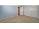 Light blue bedroom with ample closet space, with bright white doors, beige carpet, and ensuite access at 29 Desert Highlands Dr, Henderson, NV 89052